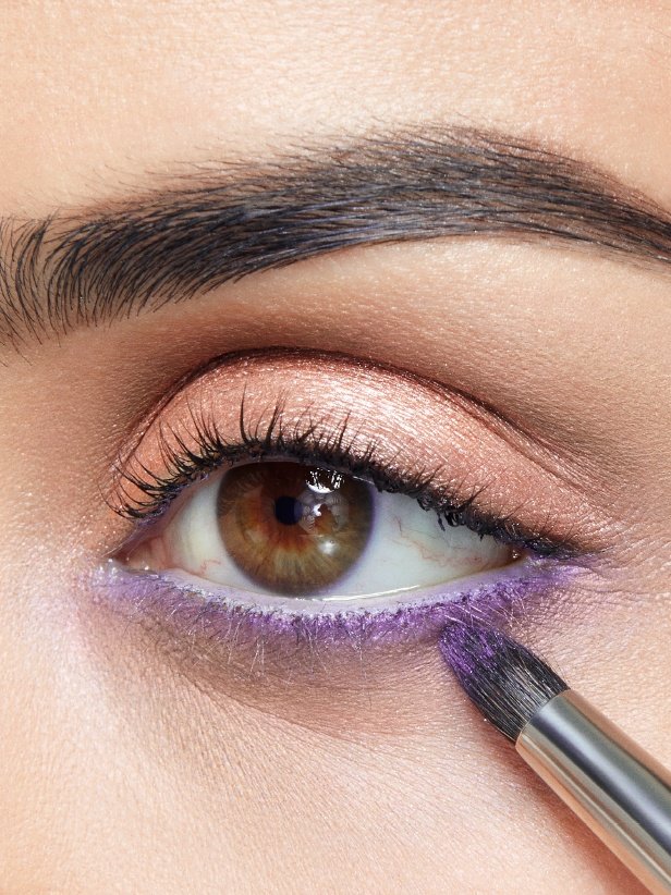 Жінка наносить кремоподібно-гелеві тіні для повік Eyestudio Color Tattoo 24HR відтінку Painted Purple на нижню лінію вій